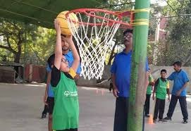 Child practising basketball with a sports coach